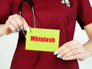 A female Doctor Holding Whiplash card