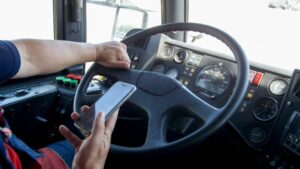 Close-up of an irresponsible man typing a phone number while driving a truck. Transport danger due to distracted driving.