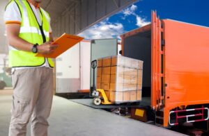 Warehouse and logistics, freight transportation. A worker in uniform inspects and checks the loading of shipments for courier transport.