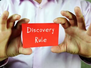 The phrase "Discovery Rule" is presented on a page, illustrating the legal principle that allows the statute of limitations to begin when an injury or harm is discovered, rather than when the incident occurred.