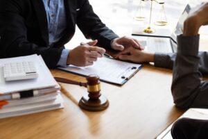 A lawyer and client review a contract document together, discussing the legal terms. They are in a professional setting, emphasizing the importance of signing a business agreement.