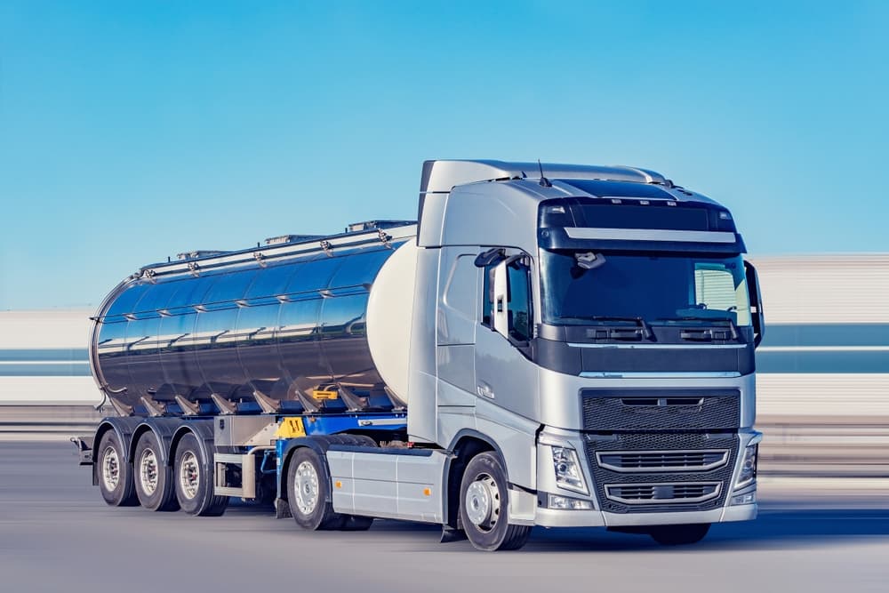 A tanker truck travels down the highway carrying freight.